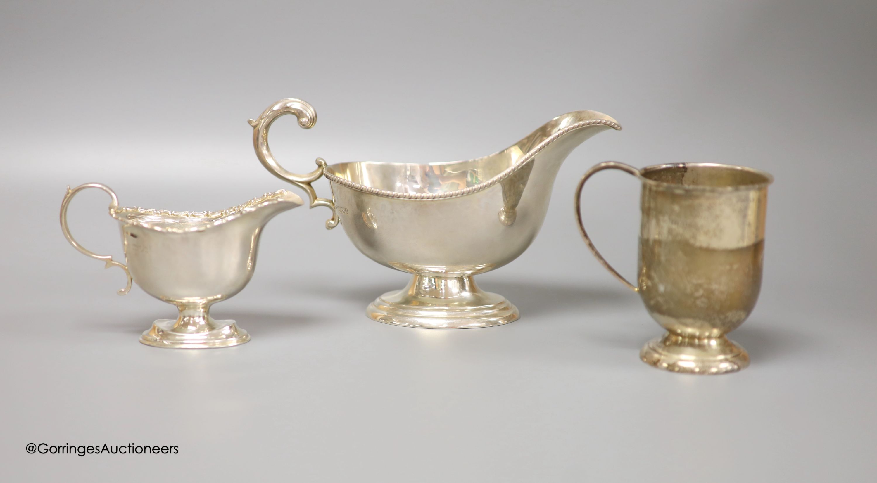 A Victorian silver cream boat, a small silver pedestal helmet cream jug and a silver Christening mug, gross 8.7oz